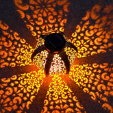 Decorative lantern casting intricate patterns on a wall